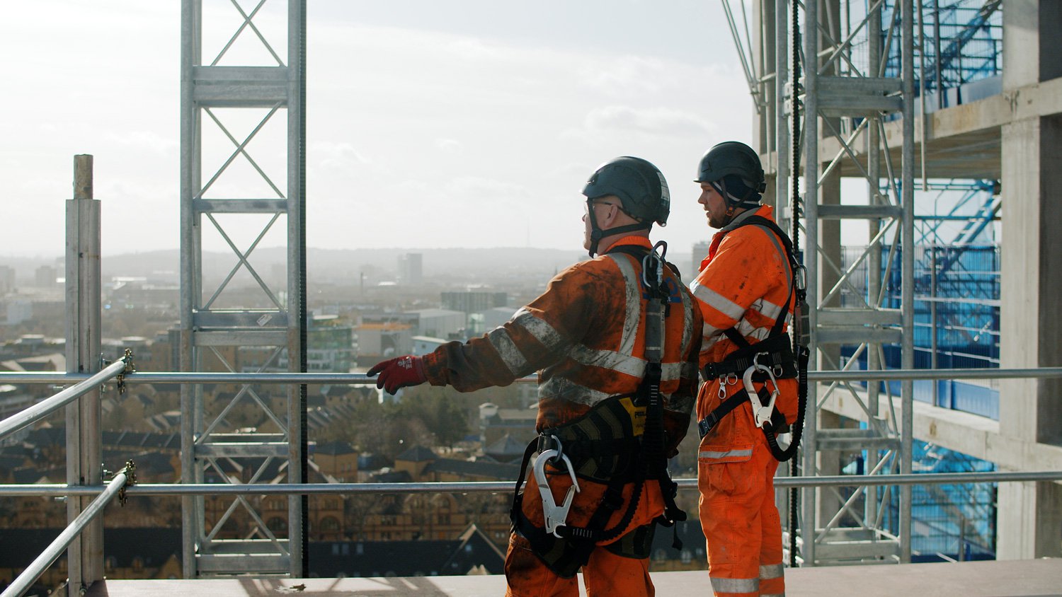 Hoist engineers from RECO Hoist Hire & Sales at work at a construction site wearing safety equipment