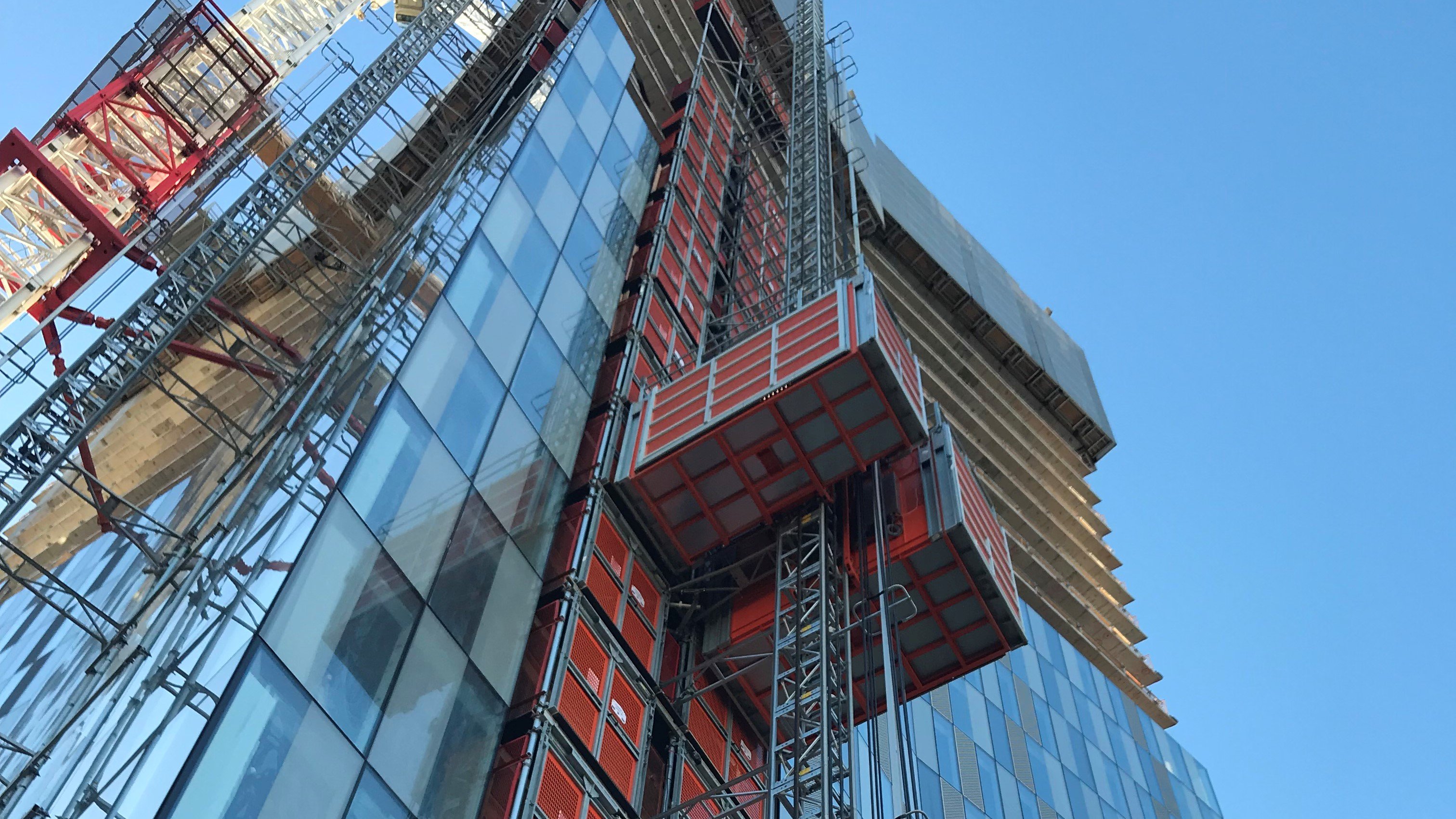 Two Alimak Scando construction hoists in twin-configuration at a huigh-rise building site